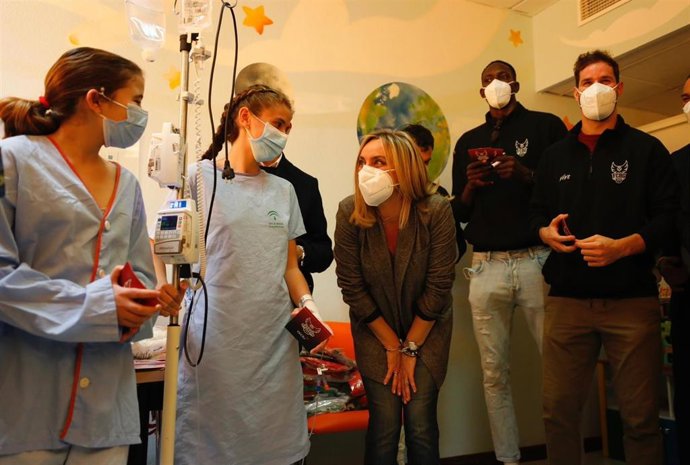 La consejera de Fomento, Articulación del Territorio y Vivienda, Marifrán Carazo, en una visita al Hospital Materno Infantil de Granada junto a jugadores de la Fundación Club Baloncesto Granada.