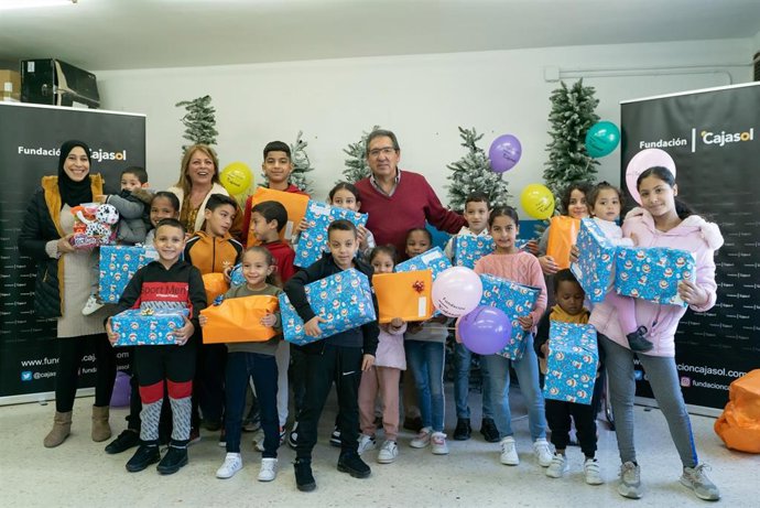 El presidente de la Fundación Cajasol, Antonio Pulido, entrega juguetes a los niños de la ONG Cooperación Internacional en el marco de la campaña 'Un juguete, una ilusión'