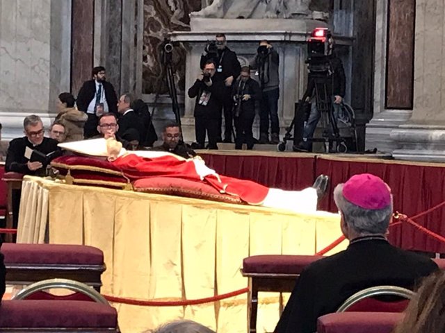 El arzobispo de Urgell y copríncipe de Andorra, Joan-Enric Vives, de espaldas, reza frente al cuerpo del Papa emérito Benedicto XVI