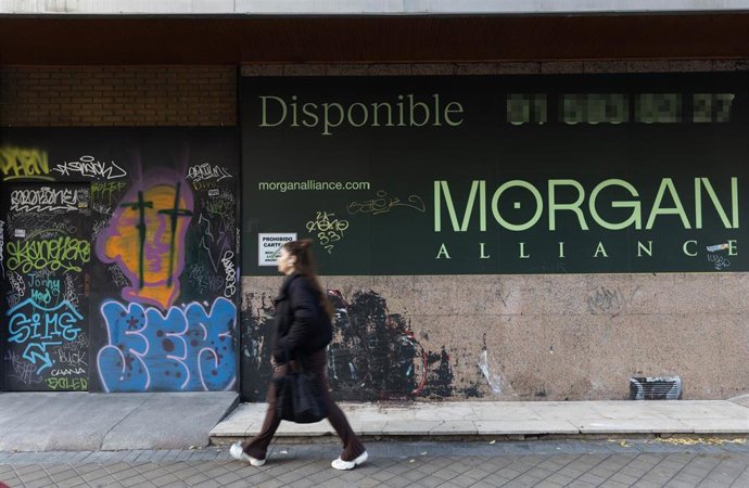 Una persona pasa por delante de un comercio cerrado
