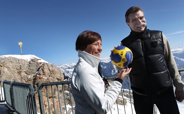 Archivo - El entrenador nacional alemán de balonmano Heiner Brand (derecha) y la ex esquiadora alpina Rosi Mittermaier juegan con una pelota de balonmano en el Zugspitze