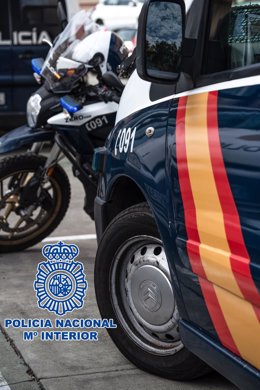Archivo - Motocicleta y coche patrulla de la Policía Nacional