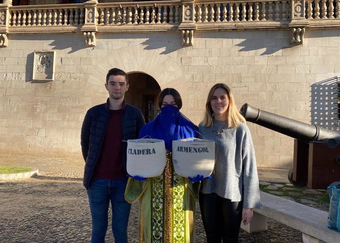 El presidente de NNGG en Mallorca, Andreu Homar, y la presidenta de NNGG en Baleares, Lourdes Roca, acompañan al "paje real" frente al Consolat de Mar.