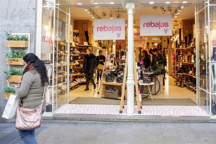 Archivo - Varias personas en el interior de una tienda de zapatos de Madrid