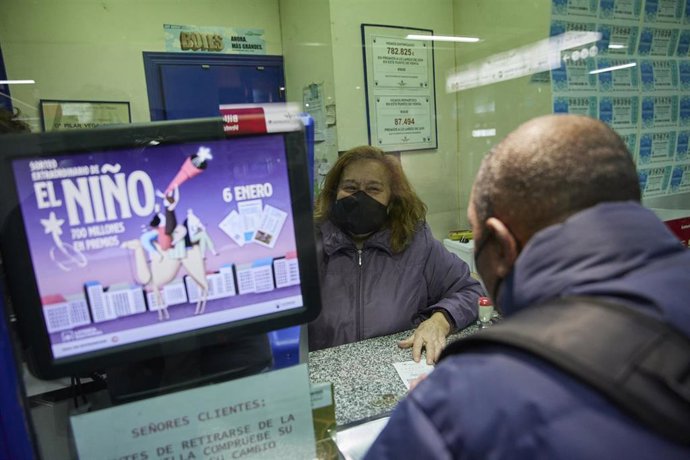 Archivo - Una empleada en una administración de lotería despacha décimos para el Sorteo Extraordinario de 'El niño'.