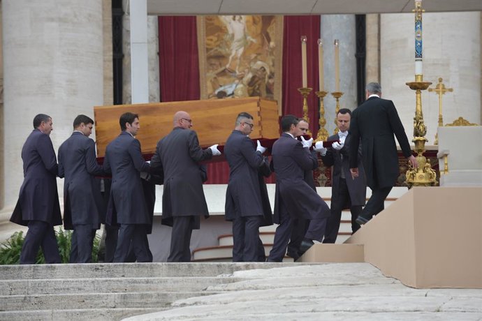 Varios hombres trasladan el féretro del pontífice emérito, Benedicto XVI, en la basílica de San Pedro, a 5 de enero de 2023, en Ciudad del Vaticano, Roma (Italia). Benedicto XVI, de nombre secular Joseph Aloisius Ratzinger falleció el pasado 31 de dicie