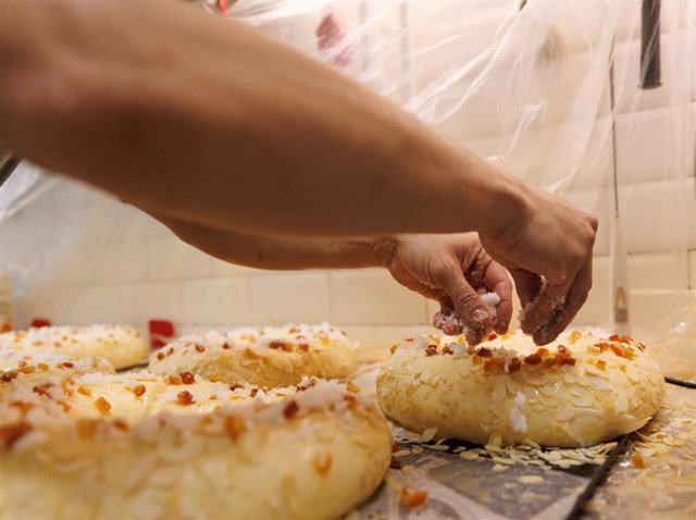 Un pastelero adorna un roscón de Reyes
