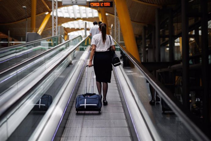 Archivo - Una azafata en las escaleras mecánicas de la Terminal 4 (T4) del aeropuerto Adolfo Suárez Madrid-Barajas, a 8 de junio de 2022, en Madrid, (España).