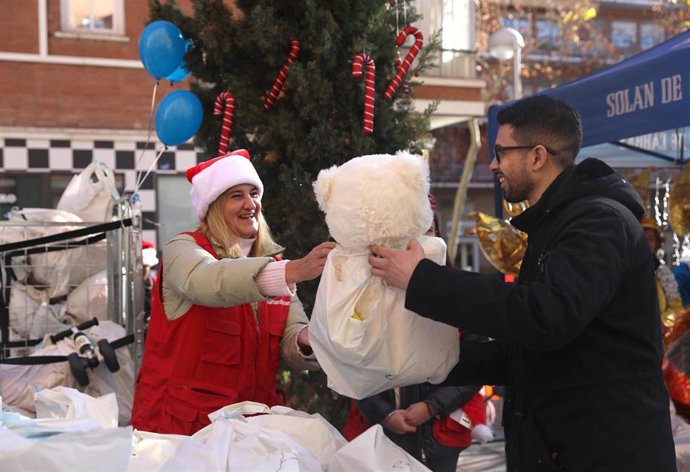 Una voluntaria de la Fundación Madrina en la entrega de regalos para los niños de las conocidas de las 'colas del hambre', en la plaza de San Amaro, a 5 de enero de 2023, en Madrid (España). 