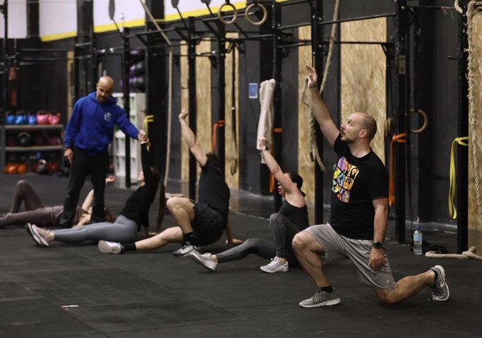 Archivo - Varias personas realizan ejercicio en un gimnasio.