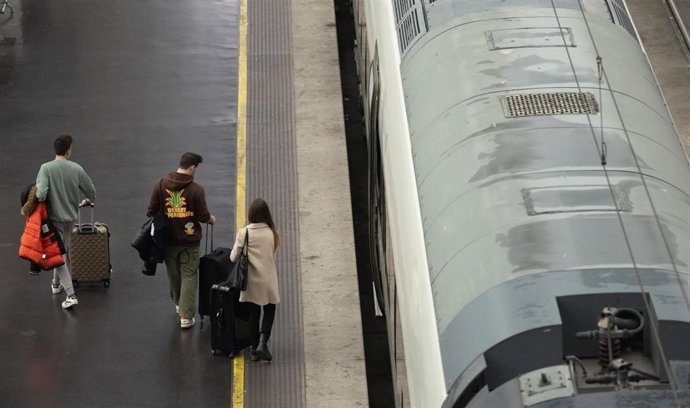 Viajeros junto a un tren