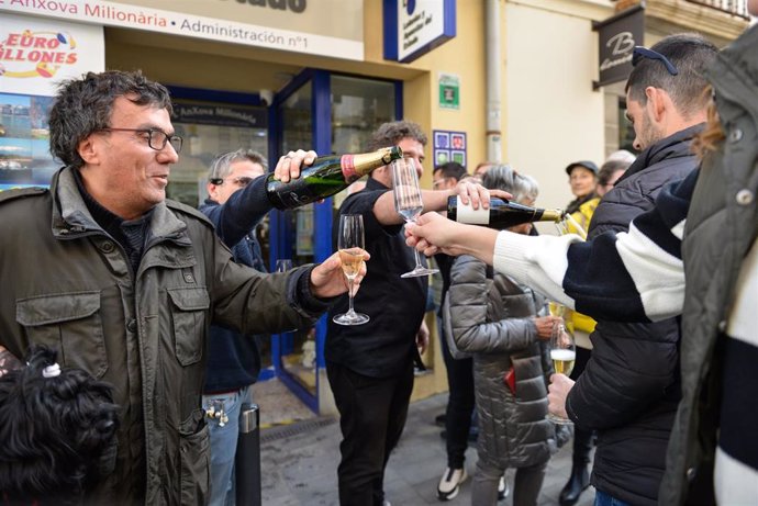 Agraciados con el primer premio del Sorteo Extraordinario de la Lotería del Niño correspondiente al número 89.603 celebran su suerte en la administración 1 situada en la calle Pintor Enric Serra, a 6 de enero de 2023, en LEscala, Girona. 