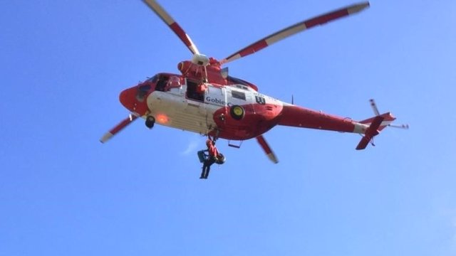 El helicóptero del Grupo de Emergencias y Salvamento (GES) del Gobierno de Canarias procede al rescate de una parapentista accidentada en el municipio de Adeje, en el sur de Tenerife