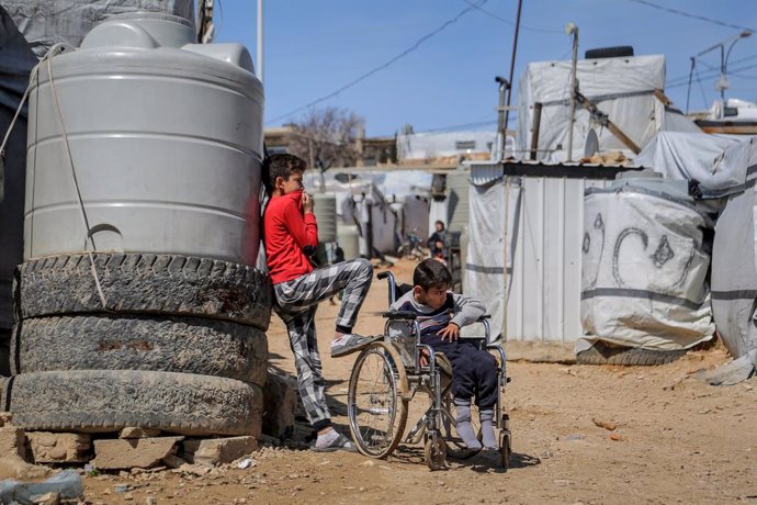 Archivo - 13 March 2021, Lebanon, Aarsal: A Syrian boy stands with his wheelchair bound brother at the Barra refugee camp in the Lebanese town of Aarsal, located north-east of capital Beirut. UNICEF said that after 10 years since the start of the Syrian