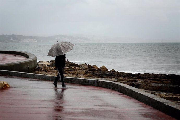 Una persona con un paraguas bajo la lluvia en Portugal