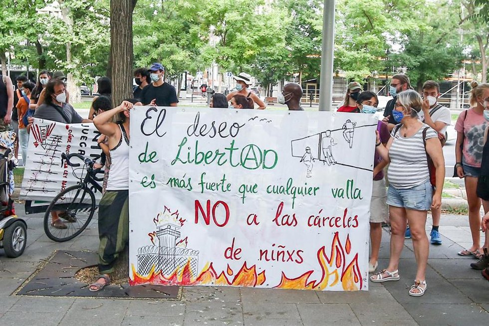 Archivo - Participantes llevan un cartel que dice 'El deseo de libertad es ás fuerte que cualquier valla. NO a las cárceles de niñxs'