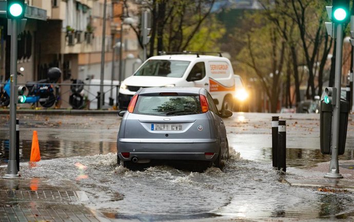 Un coche circula por una balsa de agua