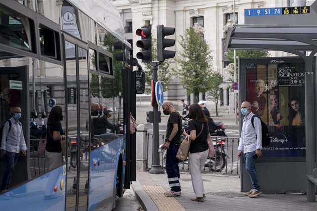 Archivo - Varias personas suben a un autobús de la Empresa Municipal de Transportes (EMT), en la plaza de Cibeles. Archivo.