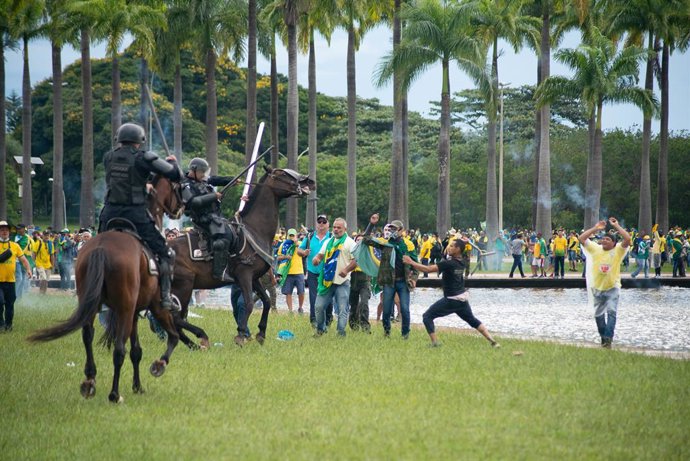 08 January 2023, Brazil, Brasilia: Supporters of former Brazilian President Jair Bolsonaro clash with mounted police in the capital. Supporters of former Brazilian President Bolsonaro have stormed the Congress and Supreme Court. Photo: Matheus Alves./dpa