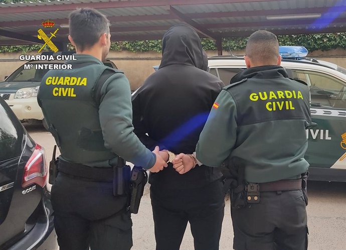 El detenido, esposado, junto a dos agentes de la Guardia Civil