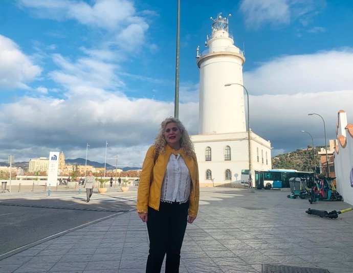 La coordinadora local de IU Málaga, Remedios Ramos, junto a la Farola, uno de los inmuebles que se vería afectado  por la construcción de un rascacielos en el dique de Levante del Puerto.