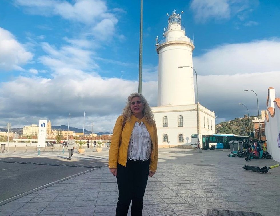 La coordinadora local de IU Málaga, Remedios Ramos, junto a la Farola, uno de los inmuebles que se vería afectado  por la construcción de un rascacielos en el dique de Levante del Puerto.