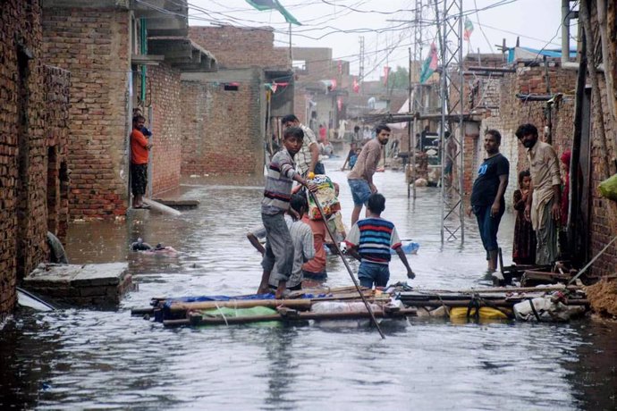 Archivo - 26 August 2022, Pakistan, Hyderabad: People wade through a flooded road after monsoon rains submerged the area. Photo: -/PPI via ZUMA Press Wire/dpa