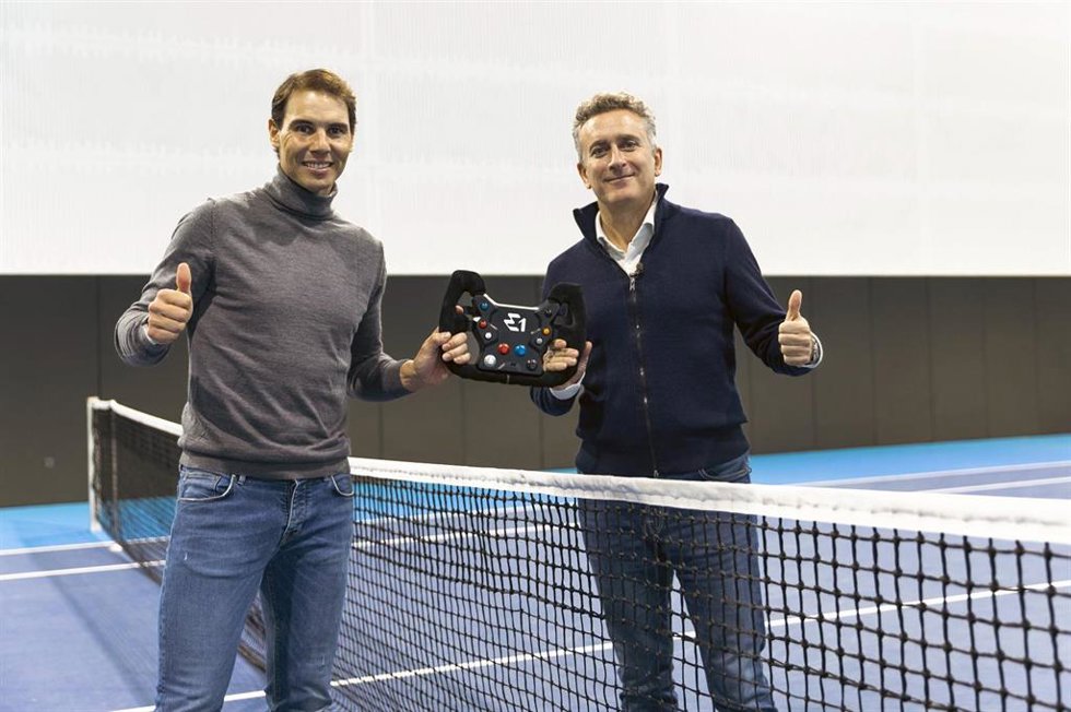 Rafa Nadal y Alejandro Agag, cofundador y presidente de E1, juntos en la pista de la Rafa Nadal Academy sosteniendo el volante de la embarcación eléctrica de competición