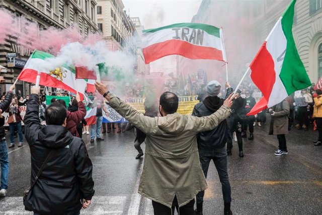 Manifestantes con pancartas y banderas contra el régimen de Irán en una marcha en Roma