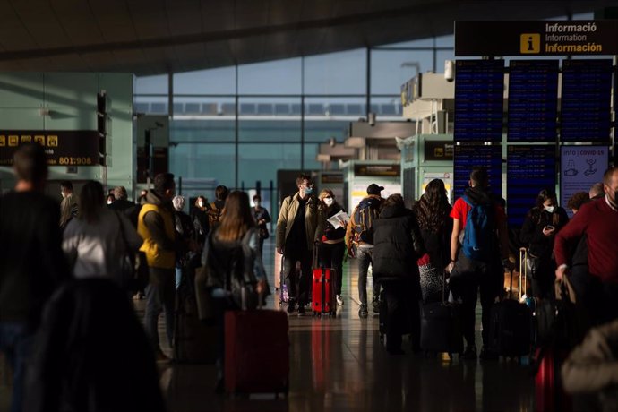 Archivo - Varios pasajeros con maletas en el Aeropuerto de Barcelona-El Prat.