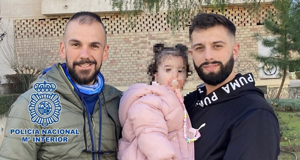Agente de la Policía Nacional, junto a la bebé a la que reanimó en parada cardiorrespiratoria y su padre