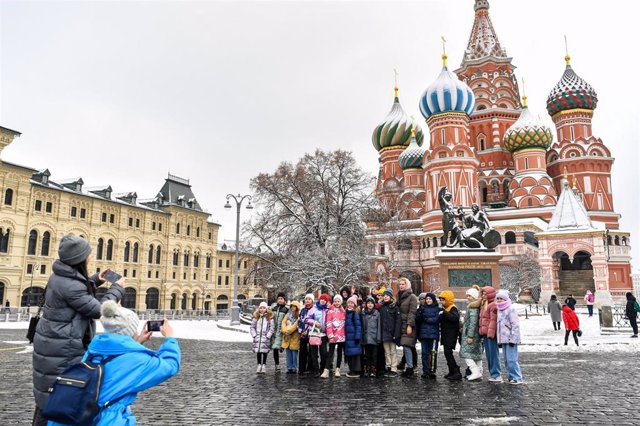 Archivo - Un grupo posa para una foto en la plaza Roja de Moscú, frente a la catedral de San Basilio
