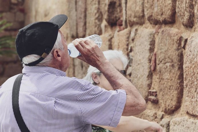 Archivo - Un hombre con gorra bebe de una botella de agua.