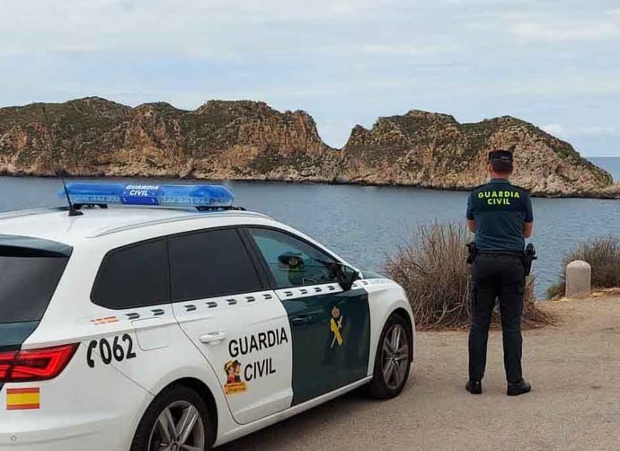Archivo - Coche patrulla y agente de la Guardia Civil