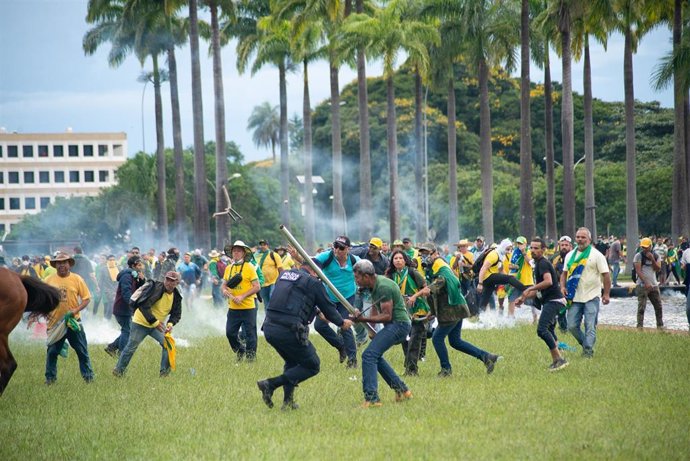 Seguidores de Jair Bolsonaro golpean a un policía durante el asalto a los tres poderes.
