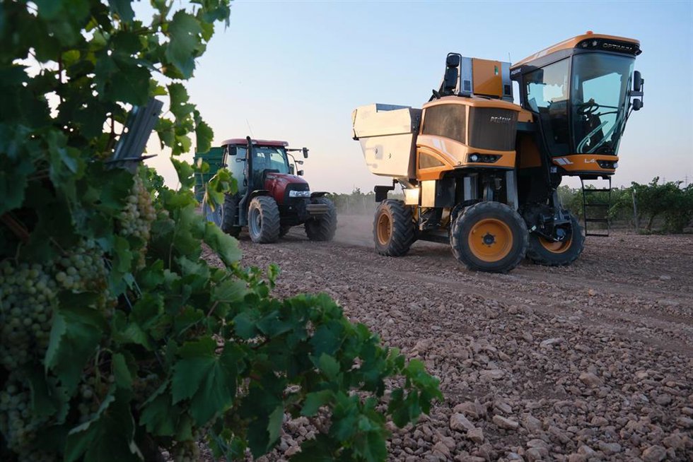 Archivo - Una vendimiadora y un tractor 