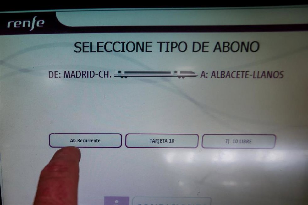 Archivo - Un pasajero saca un abono recurrente de una máquina expendedora.