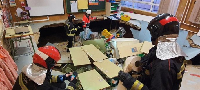 Bomberos de Gijón inspeccionan un aula de Infantil del colegio público Rey Pelayo tras derrumbarse el suelo, en Gijón