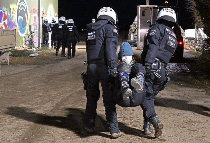 11 January 2023, North Rhine-Westphalia, Erkelenz: Police officers carry away a demonstrator during the evacuation of the village of Luetzerath. Scuffles erupted on Wednesday as police entered the German mining village of Luetzerath to clear the site of