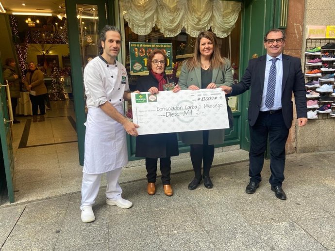 La premiada (2I) con el cheque de 10.000 euros y responsable de la confitería.