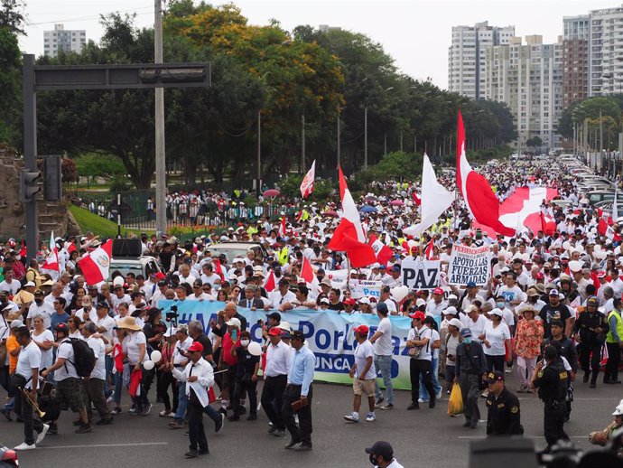 03 January 2023, Peru, Lima: Protesters hold placards and flags as hundreds march for peace in Lima and main cities along the country after the last December riots against the current government of Dina Boluarte and the Congress that left more than 20 d