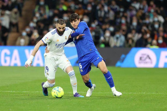 Archivo - El jugador del Real Madrid Karim Benzema pugna por un balón con el mediocentro del Getafe Gonzalo Villar en la temporada 2021-2022.