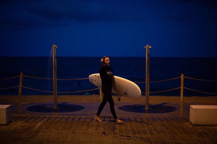 Archivo - Un joven se ducha tras practicar surf en la playa de la Barceloneta, a 4 de agosto de 2021, en Barcelona, Catalunya (España). 