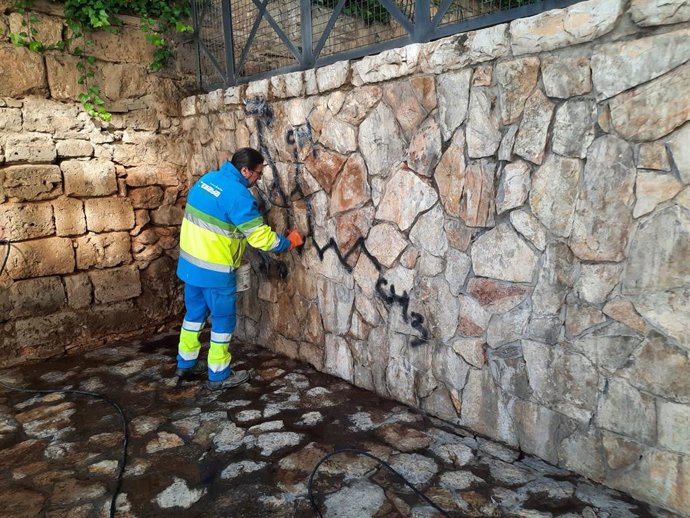 Un operario de Emaya limpia una pintada vandálica en las escaleras de la plaza Mediterrnea.
