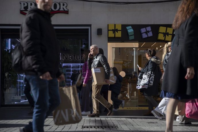 Varias personas con bolsas de la compra en una calle céntrica. A 04 de enero de 2023, en Sevilla (Andalucía, España).