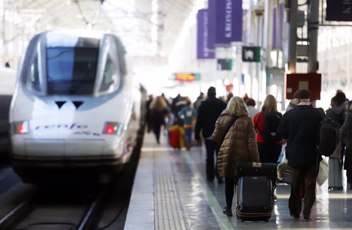 Varios viajeros en una estación de tren.