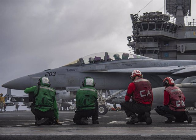 Pilotos estadounidenses preparando un avión a bordo del portaaviones USS Nimitz