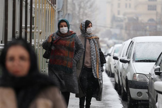 11 January 2023, Iran, Tehran: Iranian women wearing face mask walk amid the snow in Tehran. Photo: Rouzbeh Fouladi/ZUMA Press Wire/dpa