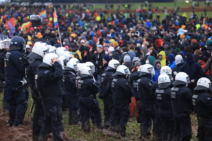 14 January 2023, North Rhine-Westphalia, Erkelenz: Police officers and demonstrators confront each other during the demonstration of climate activists at the edge of the opencast lignite mine near Luetzerath. The energy company RWE wants to excavate the