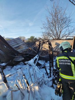 Bomberos junto a la caseta destrozada por el fuego